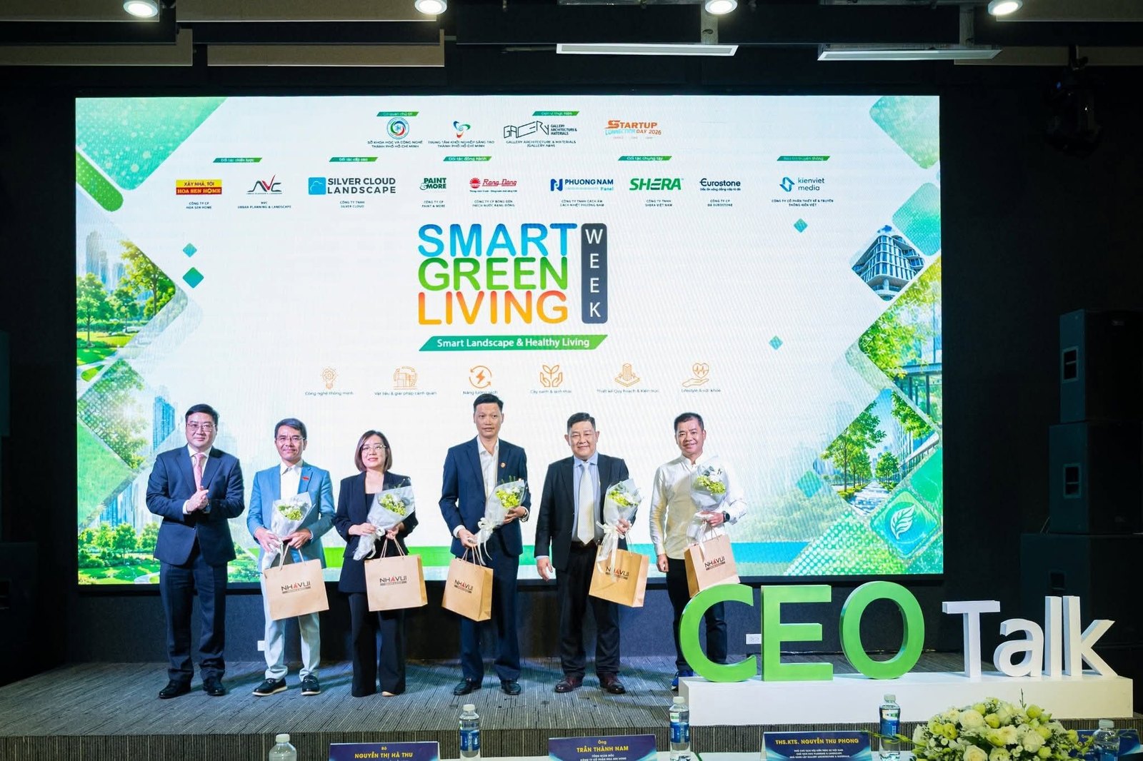 Đại diện các đơn vị đối tác nhận hoa trên sân khấu Smart Green Living Week, logo Silver Cloud Landscape trên màn hình