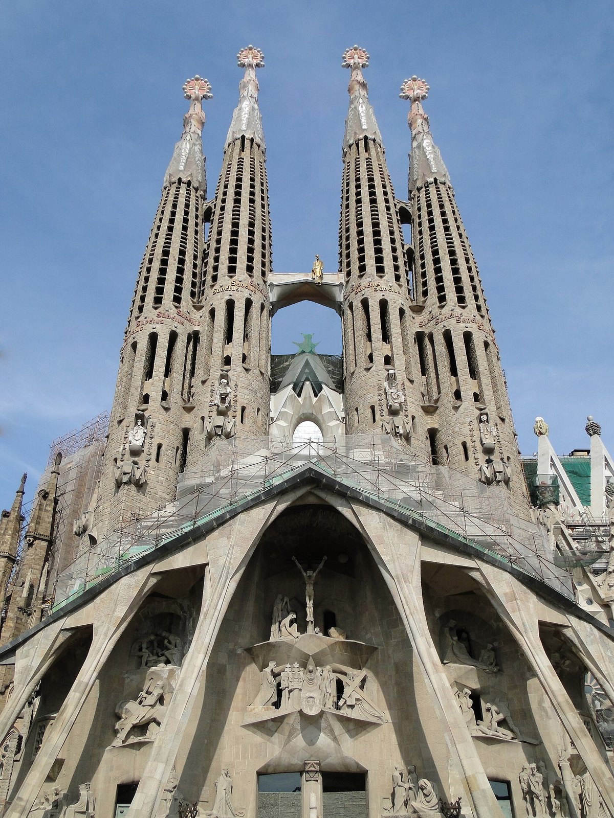 Mặt đứng Thương Khó của Sagrada Família với bốn tháp tông đồ và các cụm điêu khắc góc cạnh của Subirachs