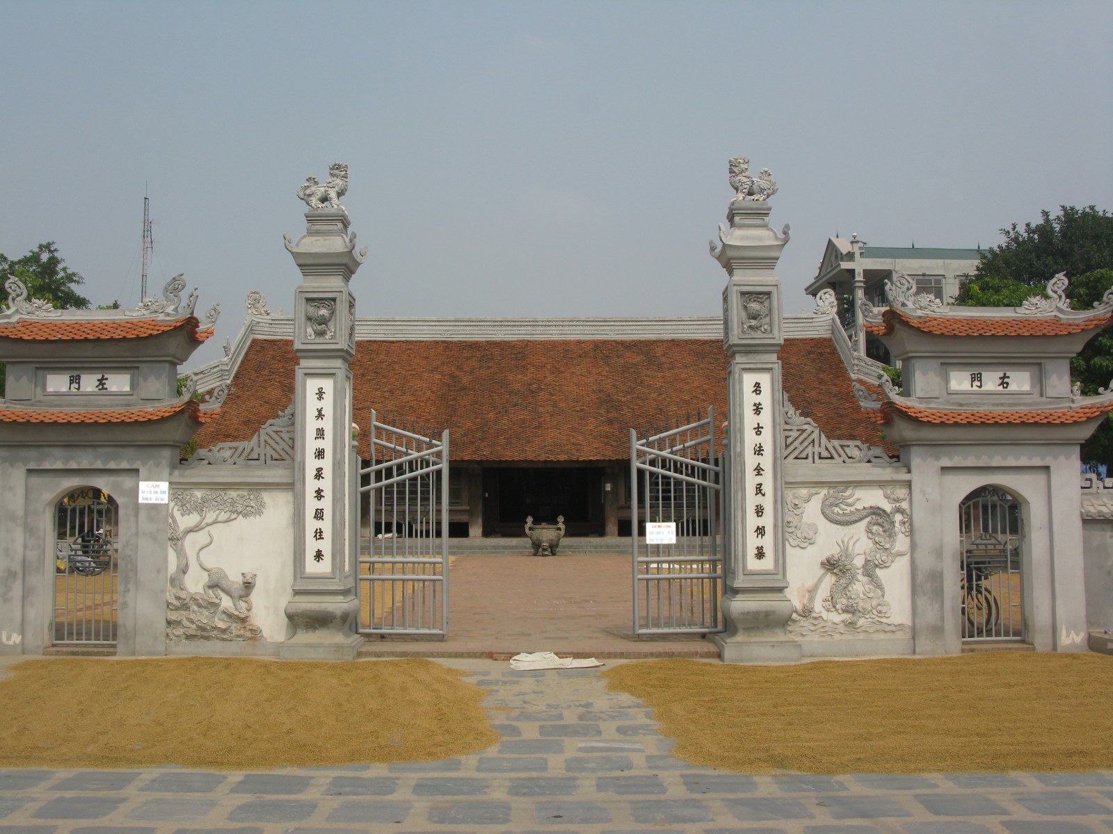 Cổng đình xây hai trụ biểu cao, phía sau là mái đình vươn ra, sân lát gạch phía trước