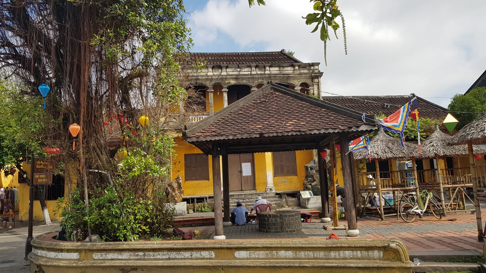 Toàn cảnh phố cổ Hội An nhìn từ trên cao: các dãy mái ngói đỏ nâu san sát, xen giữa là cây xanh và con đường nhỏ