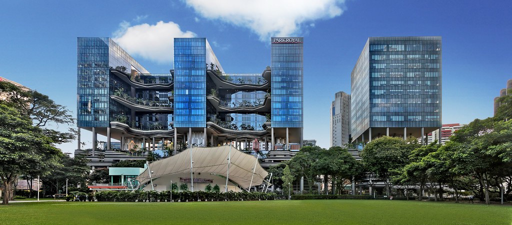 Khoảng sân trong của PARKROYAL Collection Pickering về đêm với các chao đèn hình lồng chim, cây trồng trong chậu lớn đặt sát mặt sàn