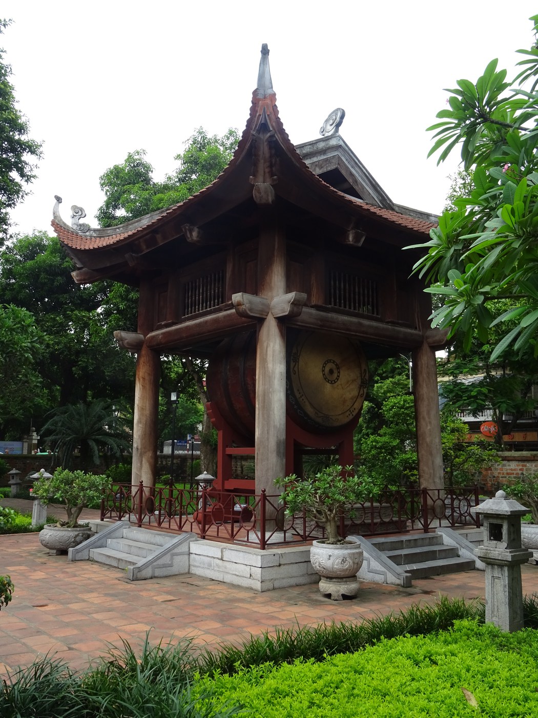 Nhà trống trong khuôn viên Văn Miếu — Quốc Tử Giám, mái cong nhiều tầng, bốn cột gỗ lớn đỡ mái, trống lớn đặt bên trong