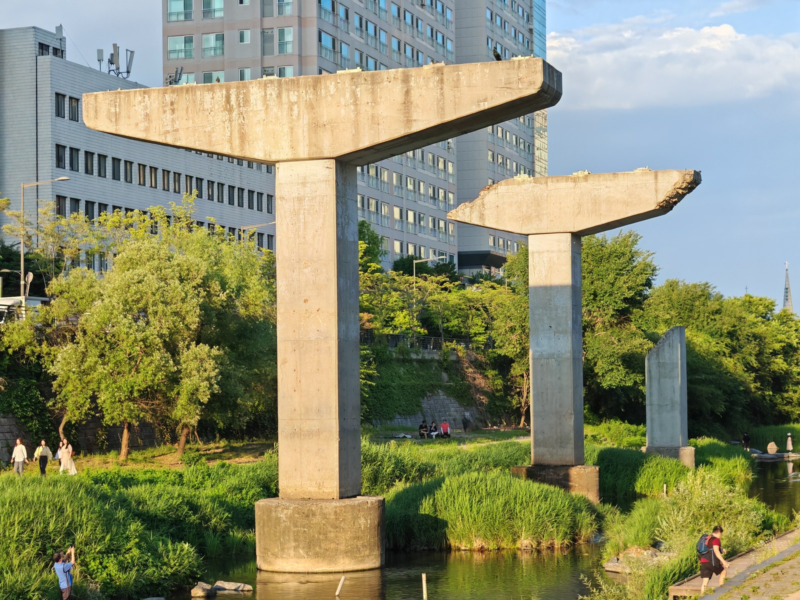 Cụm trụ bê tông cao thấp dựng sát mặt nước ở đầu dòng kênh Cheonggyecheon, Seoul