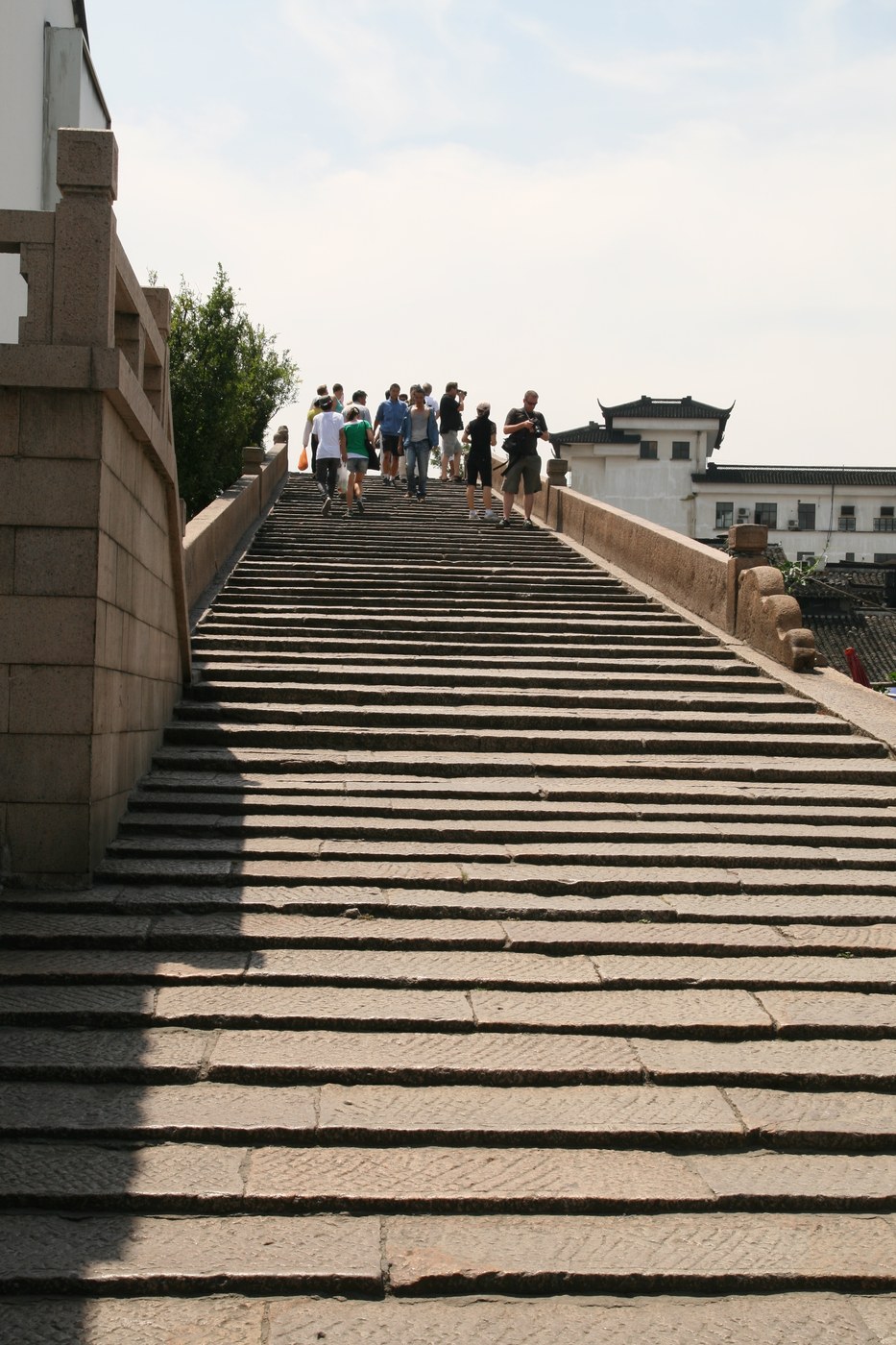 Bậc thang đá dẫn lên một cầu vòm, người đi bộ trên bậc